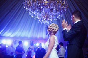Festa de casamento ilumiacao azul com noiva e noivo de costas aplaudindo os convidados