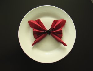 Guardanapo de Papel vermelho em formato de borboleta em cima de prato background
